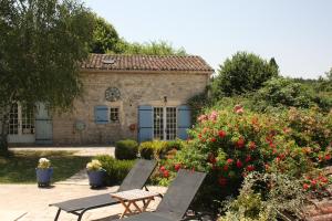 deux chaises et une table devant une maison dans l'établissement Jasmin Cottage, à Montayral