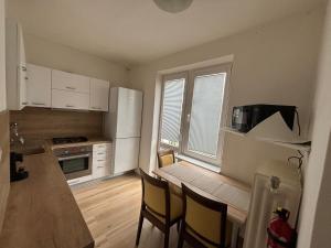 a kitchen with white cabinets and a table and chairs at PA - Peaceful Parkside Apartment in KoÅ¡ickÃ© KÃºpele