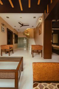 a living room with chairs and tables and a ceiling at Luxurious Duplex-Himayath nagar in Lālāguda