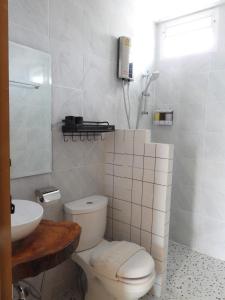 a white bathroom with a toilet and a sink at Near Khao yai National Park tour and taxi services in Mu Si
