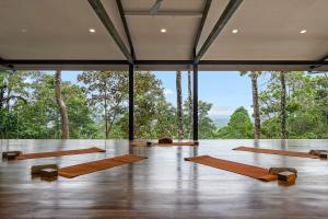 a yoga class in a room with large windows at Pandanus Lodge & Retreats Bungalow Gingiber in Cariblanco