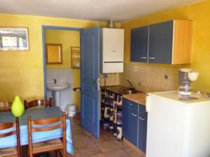a kitchen with blue cabinets and a table and a sink at Maisonette #17, 4 Pers, Domaine De Ribiere in Grospierres