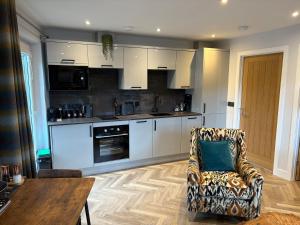 a kitchen with white cabinets and a couch and a table at The Wee Bothy in Oban