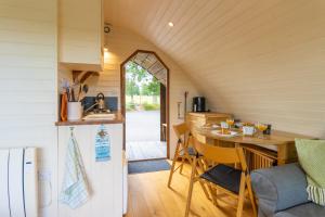 una cucina con frigorifero e tavolo con sedie di Pod2 - Powys River Pods - Pet Friendly Glamping Pod Builth Wells Powys Wales a Garth Altre 32 foto