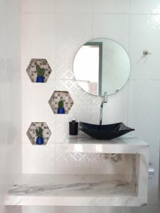 een badkamer met een wastafel en een spiegel bij Guará Apart 1 in Guaratuba
