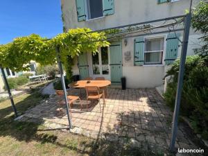 加尔加斯appartement avec piscine的房子前面的一张桌子和几把椅子