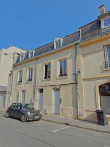 un coche aparcado frente a un edificio en una calle en Le Joyau, en Reims