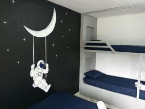 een slaapkamer met een astronaut die aan de maan hangt bij Guará Apart 1 in Guaratuba
