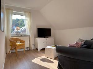 a living room with a couch and a television at Ferienwohnung am Gehrdener Berg - bis 4 Personen, Messewohnung - Hannover Fair apartment in Gehrden