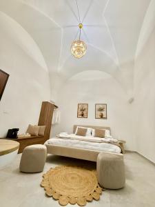 a bedroom with a large bed and a chandelier at La dimora degli ulivi in Torre Santa Susanna