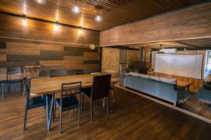 a room with a table and chairs and a projection screen at 古民家宿まるもり in Wada