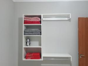 a closet with white shelves and red towels at La Bela Casa in Catanduva