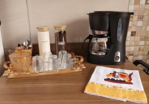 a counter with a coffee maker and cups on it at La Bela Casa in Catanduva