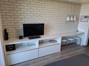 a white entertainment center with a flat screen tv at Mountain View Studio Apartment in Poprad +16 photos