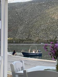 a woman in a boat on the water at Helios Panormos Sea-View Retreat in Nisída Planítis +44 photos