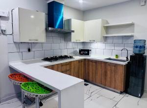 a kitchen with a white counter and wooden cabinets at Noir Escape Bahria hieghts D Block in Rawalpindi
