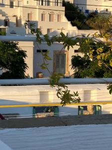 a view of a white building with buildings in the background at Helios Panormos Sea-View Retreat in Nisída Planítis