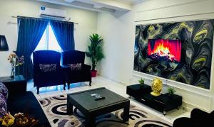 a living room with a fire in a large painting at Noir Escape Bahria hieghts D Block in Rawalpindi