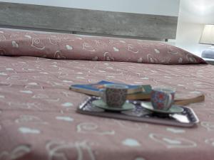 a tray with two coffee cups on a bed at Rosso Napoli locazioni brevi in Naples +86 photos