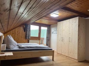 a bedroom with a bed and a wooden ceiling at Ferienwohnungen am Pietschacherhof in Hochrindl