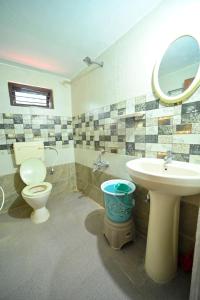 a bathroom with a toilet and a sink and a mirror at Elephant path Coorg villas in Suntikoppa +30 photos
