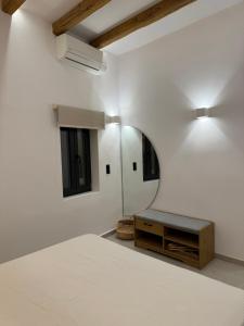 a white room with a mirror and a table at Deos luxury house in Ios Chora