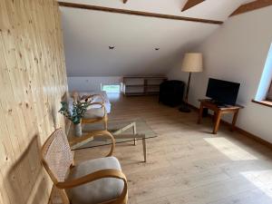 a living room with chairs and a table and a tv at Siedlisko pod Lasem in Józefów