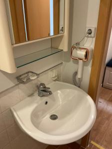 ein weißes Waschbecken in einem Badezimmer mit einem Spiegel in der Unterkunft Hotel &Restaurant Meteora in Glauchau