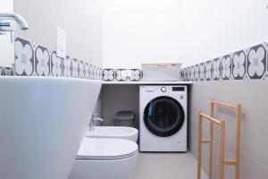a bathroom with a washing machine and a toilet at Casa di Luce in Gioia del Colle
