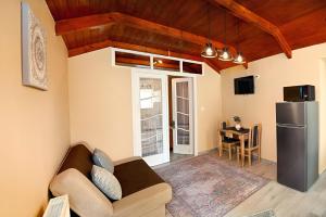 a living room with a couch and a refrigerator at Rejtekhely Apartman in Miskolc