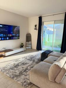 a living room with a couch and a flat screen tv at Modern Lux 3BR Home Near Disney and Lego Land! in Haines City +14 photos