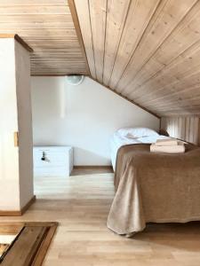 a bedroom with a bed and a wooden ceiling at Fir & Flame Lodge in Rovaniemi
