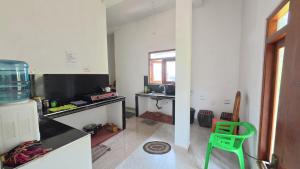 a kitchen with a green chair in a room at Green Mart Family Rest in Anuradhapura