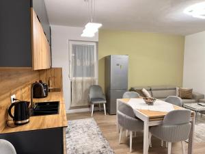a kitchen and living room with a table and chairs at Serenità Apartment in Kolgecaj
