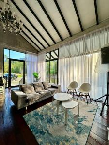 Una sala de estar con un sofá y mesas. en Villa Rindu Janda Baik, en Kampung Janda Baik