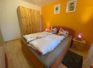 a bedroom with a bed with a yellow wall at Ferienhaus am Wald in Friedrichroda