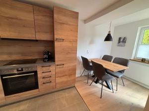 a kitchen with a table and a wooden wall at Fichtellofts in Bischofsgrün