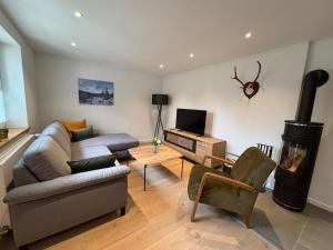 a living room with a couch and a stove at Fichtellofts in Bischofsgrün