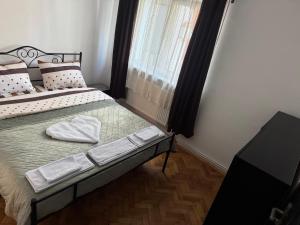 a bedroom with a bed with two white towels on it at Gollums House in Sighişoara