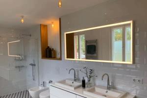 ein Badezimmer mit zwei Waschbecken und einer Toilette und einem Spiegel in der Unterkunft Landidyll - Bauernhaus Ländchen Bellin  + 48 Fotos