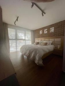 a bedroom with a large bed and a brick wall at Boutique hotel experience in Bogotá