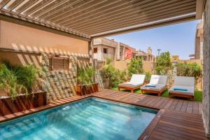 an outdoor swimming pool with a pergola and chairs at Villa Lina in Marrakech