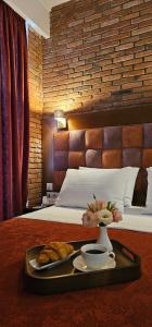 a tray with a plate of food on a bed at AMARCORD BOUTIQUE HOTEL in Tbilisi City