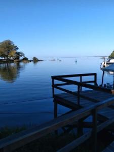 a dock on a lake with a boat in the water at Apartamento kitchenette in São Lourenço do Sul