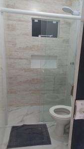 a bathroom with a glass shower with a toilet at Morada Silveira in Pinheiro