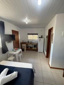 a room with a bed and a kitchen with a refrigerator at Morada Silveira in Pinheiro +6 photos