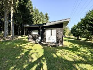 a small shed with a chair in a yard at Thak in Francorchamps