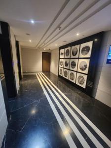 a hallway with pictures on the walls of a building at Cozy Serene 1BHK in Lodha Belmondo Golf Resort, Pune in Pune +45 photos