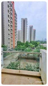 a balcony with a view of a city with tall buildings at Cozy Serene 1BHK in Lodha Belmondo Golf Resort, Pune in Pune
