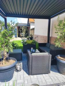 an outdoor patio with wicker furniture and potted trees at Ferienwohnung im Harz 2 in Goslar